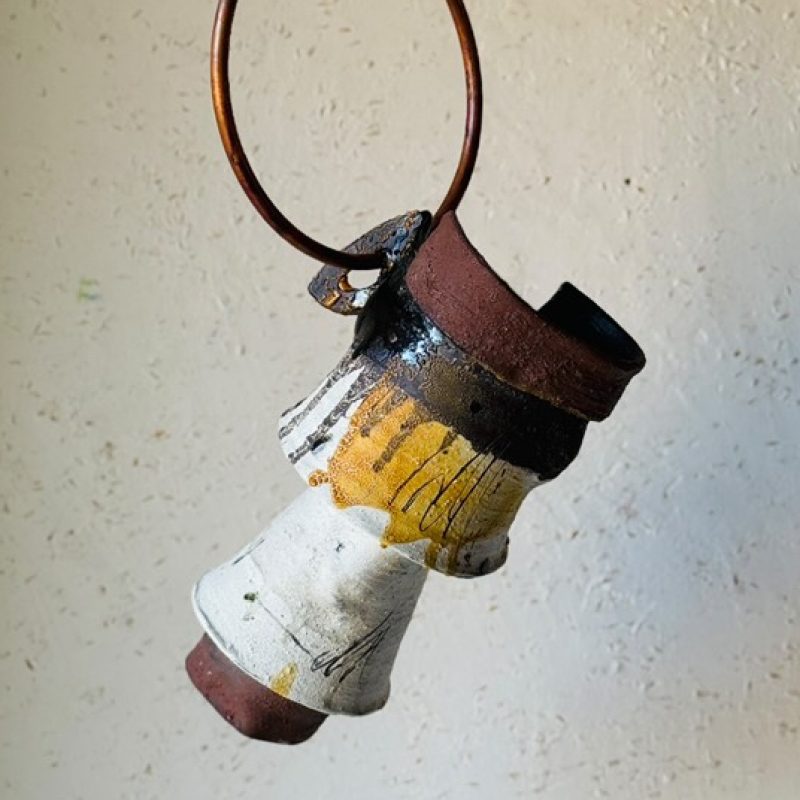 ceramic vase with metal ring hanging in the air